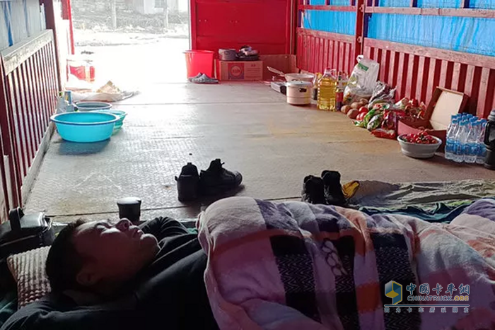 經(jīng)過2天2夜的奔襲，疲憊的張燕老公張偉正在貨箱休息