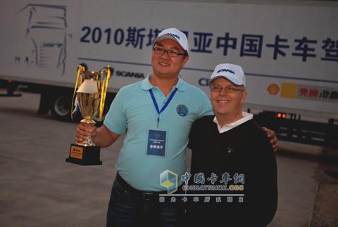 2010斯堪尼亞卡車駕駛員大賽全國總冠軍嚴(yán)軍與斯堪尼亞集團(tuán)中國戰(zhàn)略中心首席代表兼斯堪尼亞銷售（中國）有限公司執(zhí)行董事何墨池先生合影